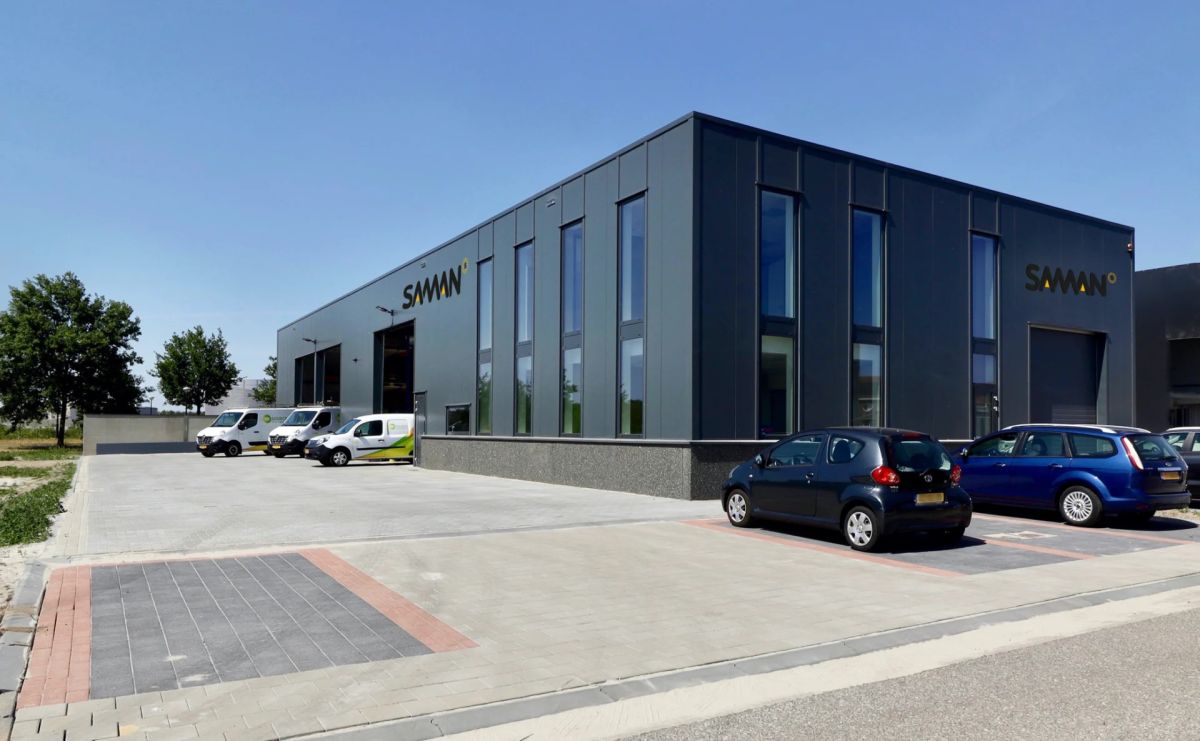 The modern building of Saman Groep with company vehicles in the parking lot, a client case of WorldEmp.